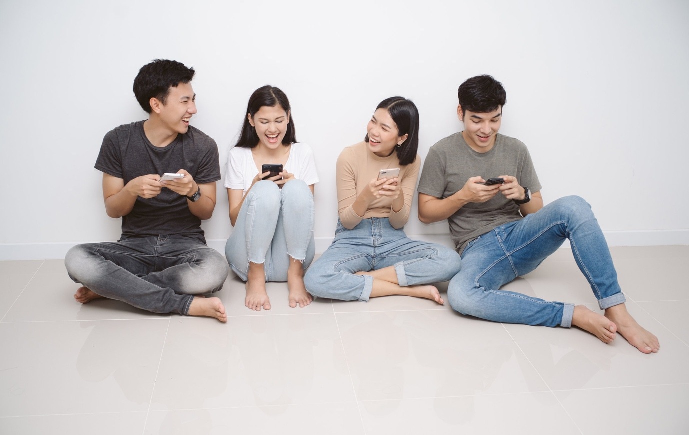 A group of people sitting on the floor playing video games Description automatically generated with medium confidence
