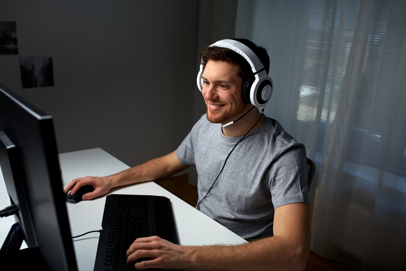 A person wearing headphones and sitting at a desk Description automatically generated with medium confidence