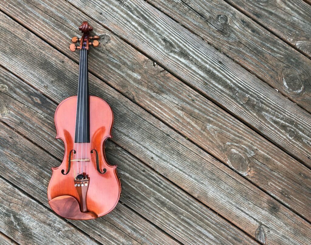 closeup photo of violin on brown surface