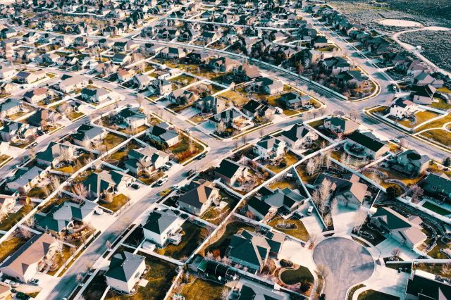 High-angle aerial shot of a suburban neighborhood in Herriman, Utah showcasing residential architecture and streets.